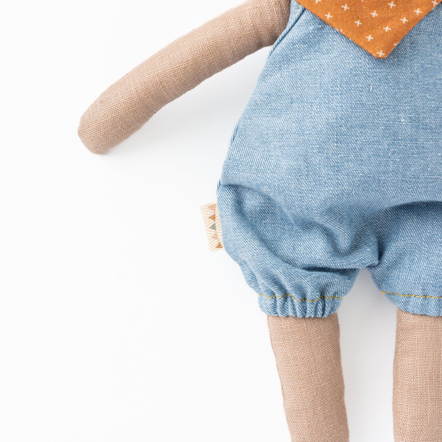 Huggabeau Soft Toys Huggabeau Sandy Bear in Blue Harem Romper & Swedish Cross Handkerchief (Handmade in Canada) Huggabeau Sandy Bear in Blue Harem Romper & Swedish Cross Handkerchief